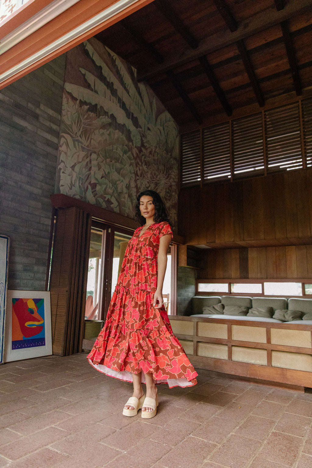 woman with brown hair wearing a flowy maxi tiered dress with retro pink pua print
