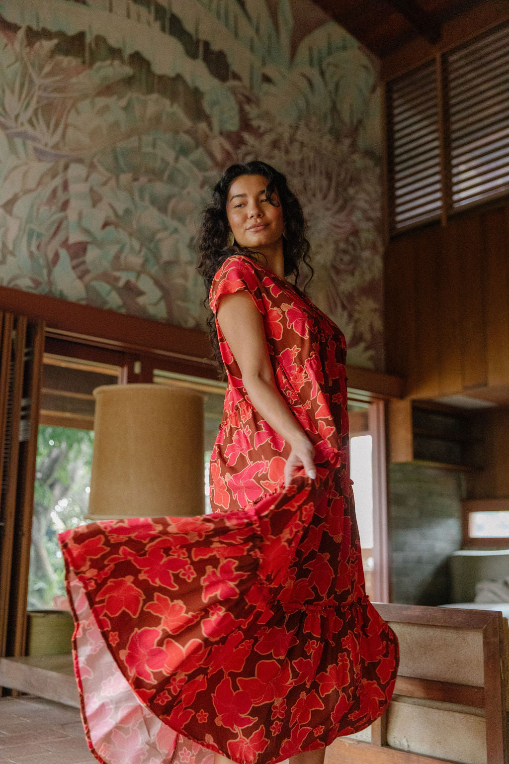 woman with brown hair wearing a flowy maxi tiered dress with retro pink pua print