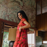 woman with brown hair wearing a flowy maxi tiered dress with retro pink pua print