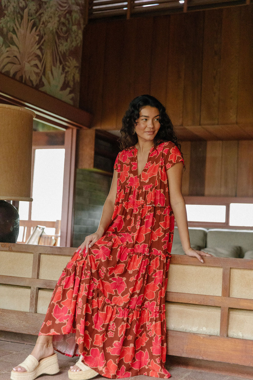 woman with brown hair wearing a flowy maxi tiered dress with retro pink pua print