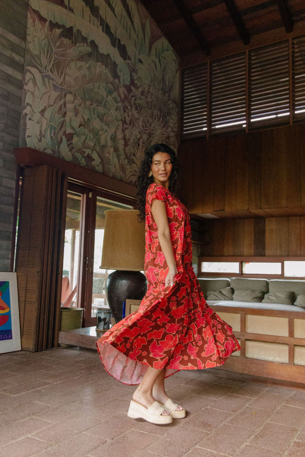 woman with brown hair wearing a flowy maxi tiered dress with retro pink pua print