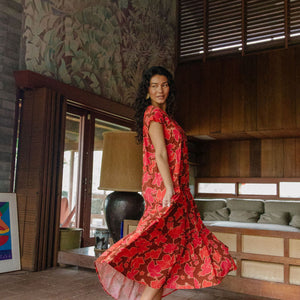 woman with brown hair wearing a flowy maxi tiered dress with retro pink pua print