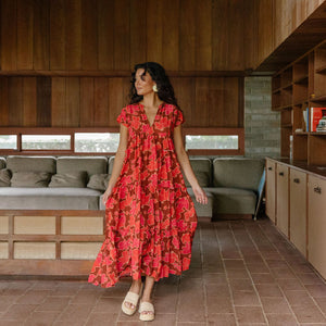 woman with brown hair wearing a flowy maxi tiered dress with retro pink pua print