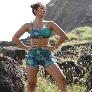 woman with brown hair wearing matching active wear sports bra and shorts set in dark blue floral pattern