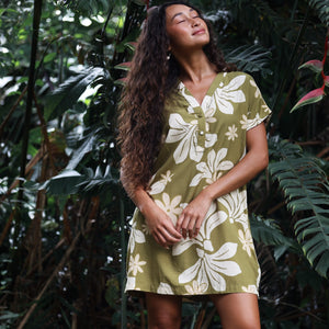 woman with brown hair wearing a shirt dress with v neck in green print with naupaka pattern