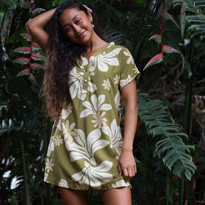 woman with brown hair wearing a shirt dress with v neck in green print with naupaka pattern