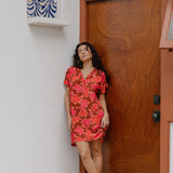 woman with brown hair wearing a half button v neck dress with retro pink pua print