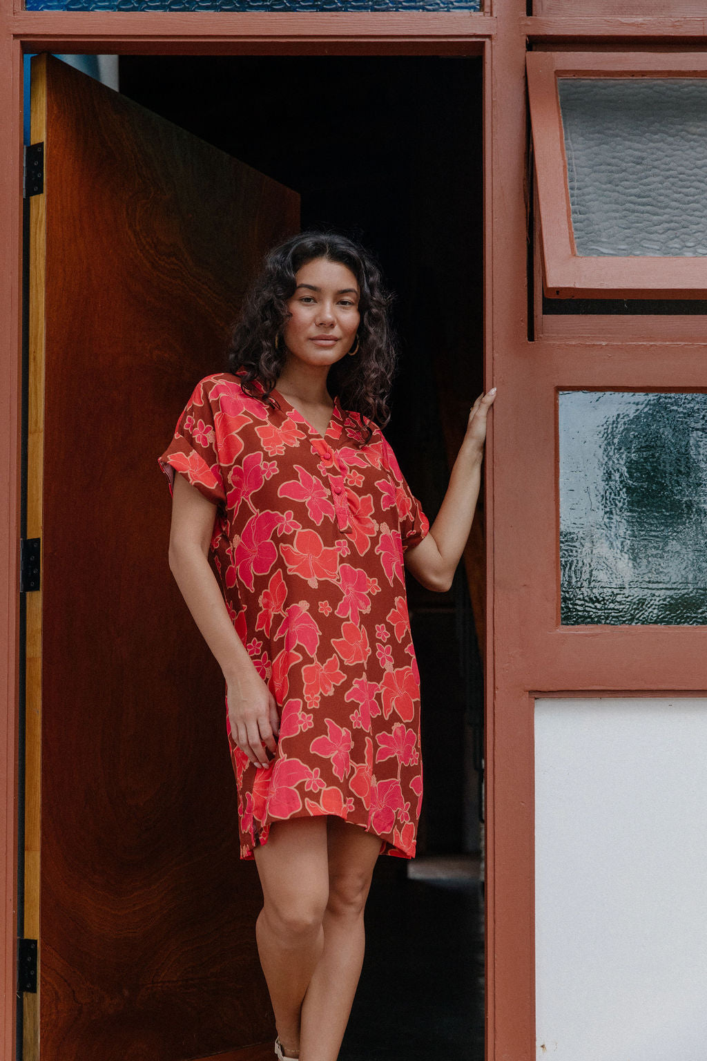 woman with brown hair wearing a half button v neck dress with retro pink pua print