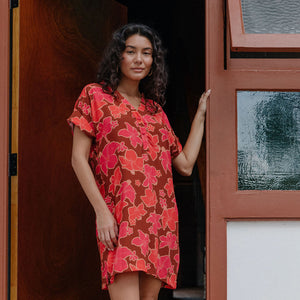 woman with brown hair wearing a half button v neck dress with retro pink pua print