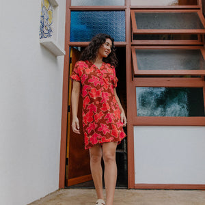 woman with brown hair wearing a half button v neck dress with retro pink pua print
