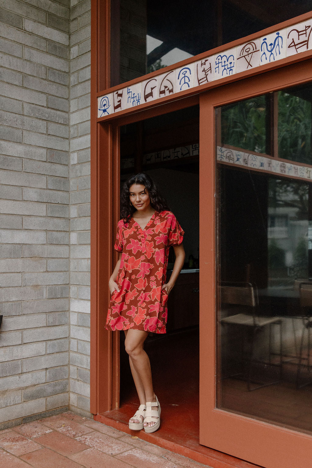 woman with brown hair wearing a half button v neck dress with retro pink pua print
