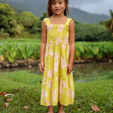 little girl wearing long flowy dress in bright green with orchid pattern
