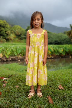 little girl wearing long flowy dress in bright green with orchid pattern
