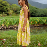 little girl wearing long flowy dress in bright green with orchid pattern