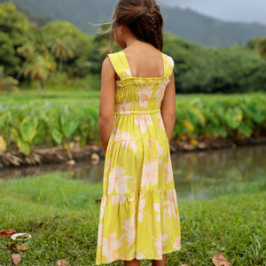 little girl wearing long flowy dress in bright green with orchid pattern