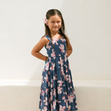 little girl wearing a tiered maxi dress in navy and pink hibiscus print.