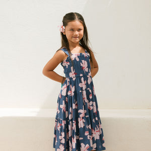 little girl wearing a tiered maxi dress in navy and pink hibiscus print.