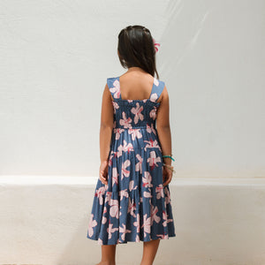 little girl wearing a tiered maxi dress in navy and pink hibiscus print.
