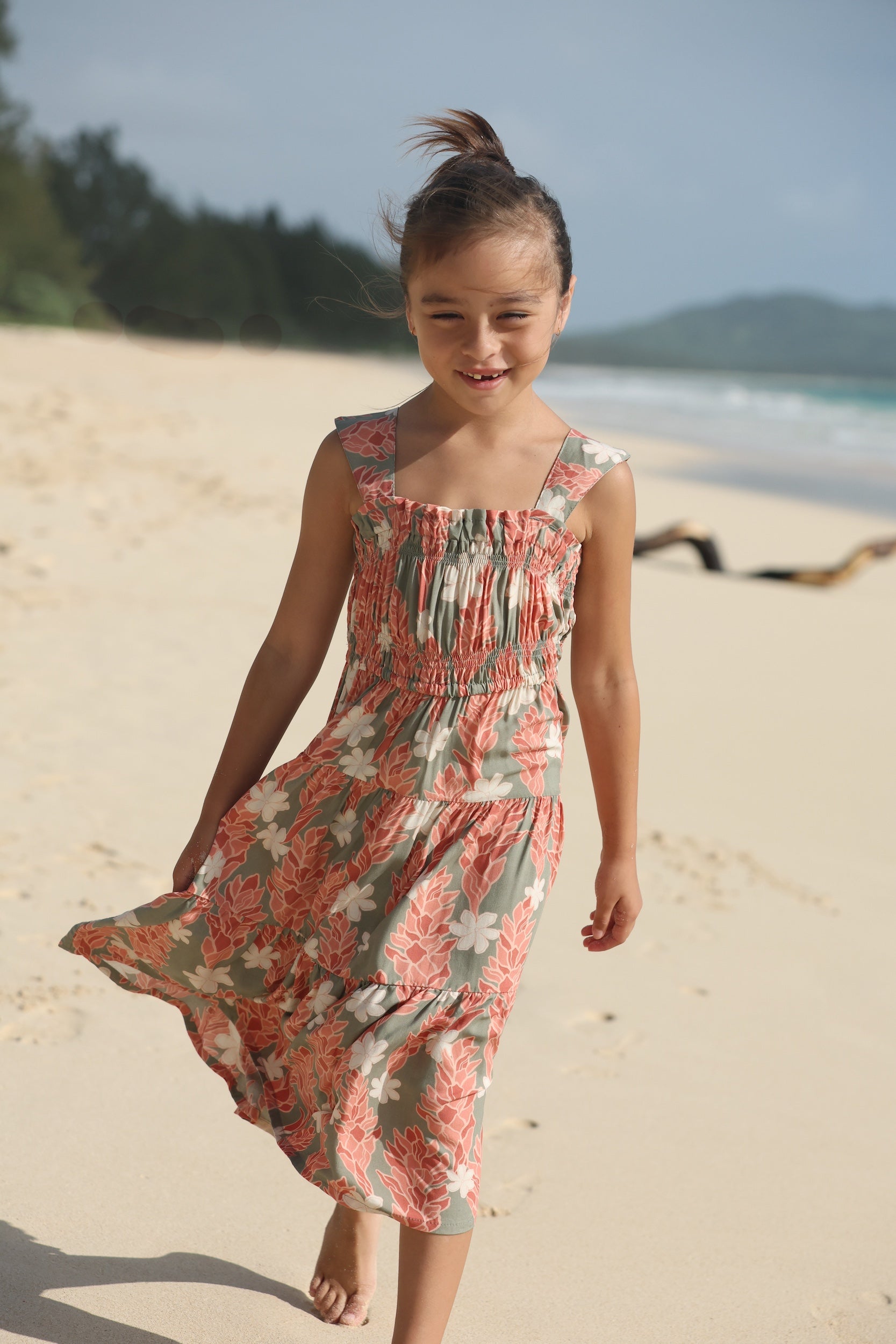 little girl wearing long jade color tiered dress with tiare ginger print