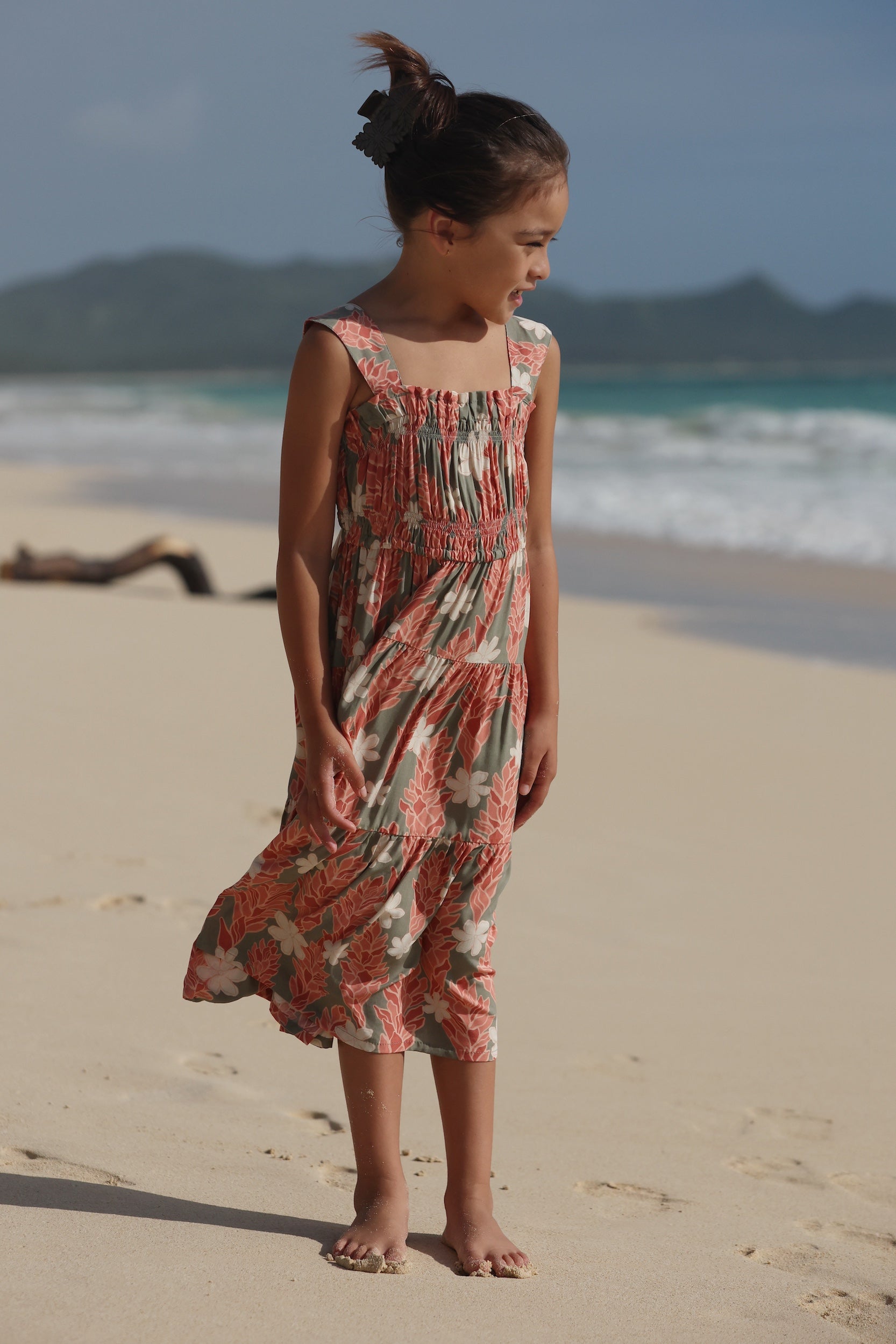little girl wearing long jade color tiered dress with tiare ginger print