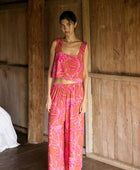 A woman with dark hair wears a YIREH wide legged pant with elastic waistband. It is the Elodi Pant in the Garden 'Awapuhi print. 