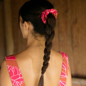 A woman with dark hair wears a YIREH flowy cropped top. It is the Naia Top in the Garden 'Awapuhi print. 