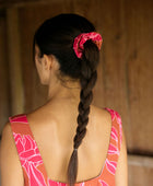 Woman wearing a scrunchie in hair in brown with pink ginger print