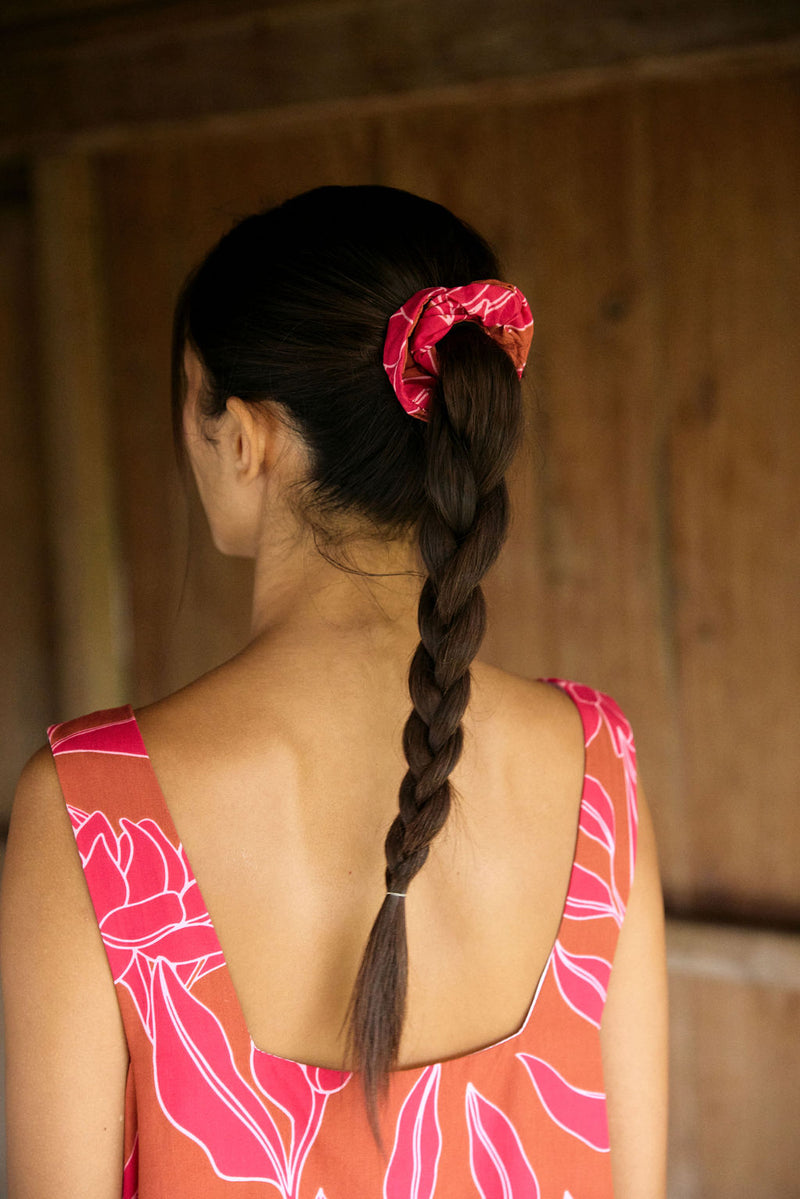 Woman wearing a scrunchie in hair in brown with pink ginger print