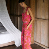 A woman with dark hair wears a YIREH flowy cropped top. It is the Naia Top in the Garden 'Awapuhi print. 
