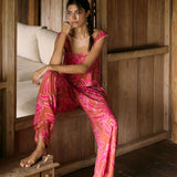 A woman with dark hair wears a YIREH flowy cropped top. It is the Naia Top in the Garden 'Awapuhi print. 
