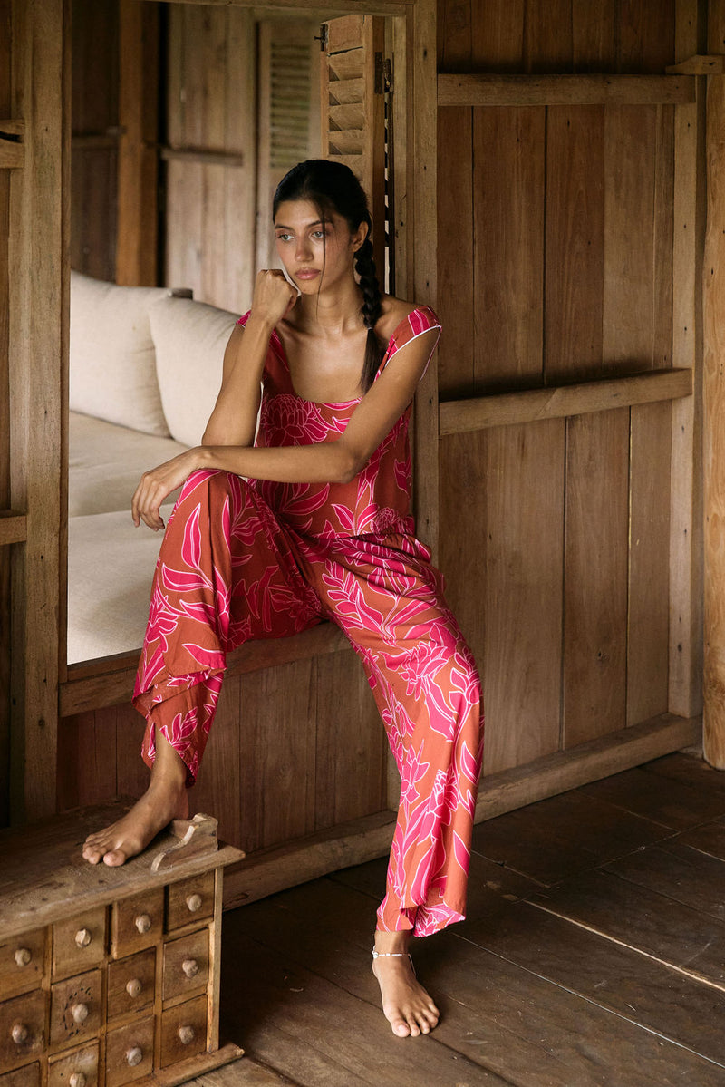 A woman with dark hair wears a YIREH wide legged pant with elastic waistband. It is the Elodi Pant in the Garden 'Awapuhi print. 