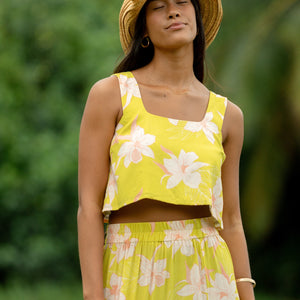 woman wearing a bright green orchid print cropped top with matching maxi skirt