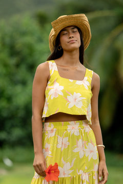 woman wearing a bright green orchid print cropped top with matching maxi skirt