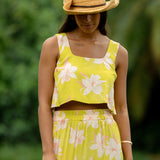 woman wearing a bright green orchid print cropped top with matching maxi skirt