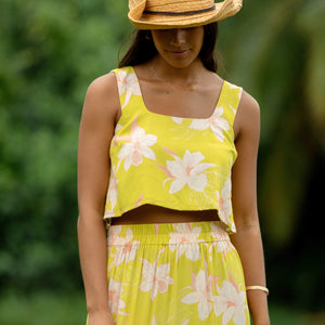 woman wearing a bright green orchid print cropped top with matching maxi skirt