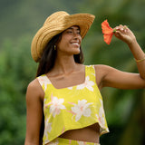 woman wearing a bright green orchid print cropped top with matching maxi skirt