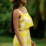 woman wearing a bright green orchid print cropped top with matching maxi skirt