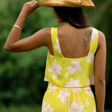 woman wearing a bright green orchid print cropped top with matching maxi skirt