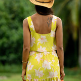 woman wearing a bright green orchid print cropped top with matching maxi skirt