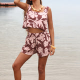 Woman with brown hair wearing a matching top and shorts set  in blush and brown hibiscus print. It is the Naia Top and Millie Shorts.