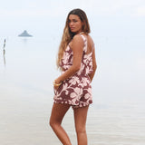 Woman with brown hair wearing a matching top and shorts set  in blush and brown hibiscus print. It is the Naia Top and Millie Shorts.