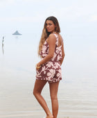 Woman with brown hair wearing a matching top and shorts set  in blush and brown hibiscus print. It is the Naia Top and Millie Shorts.