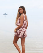 Woman with brown hair wearing a matching top and shorts set  in blush and brown hibiscus print. It is the Naia Top and Millie Shorts.