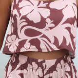 Woman with brown hair wearing a matching top and shorts set  in blush and brown hibiscus print. It is the Naia Top and Millie Shorts.