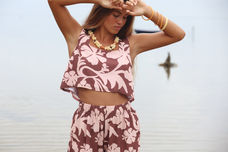 Woman with brown hair wearing a matching top and shorts set  in blush and brown hibiscus print. It is the Naia Top and Millie Shorts.