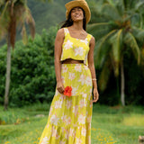 woman wearing a bright green orchid print cropped top with matching maxi skirt