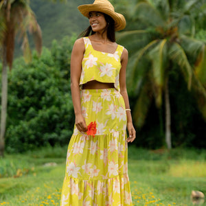 woman wearing a bright green orchid print maxi skirt with matching top