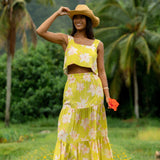woman wearing a bright green orchid print cropped top with matching maxi skirt