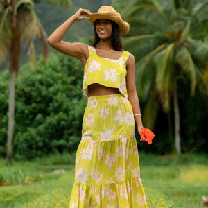 woman wearing a bright green orchid print cropped top with matching maxi skirt