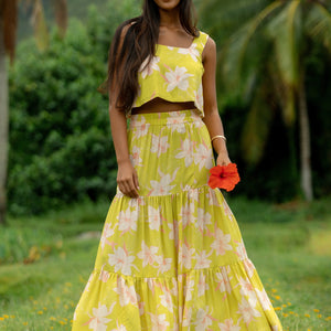 woman wearing a bright green orchid print maxi skirt with matching top